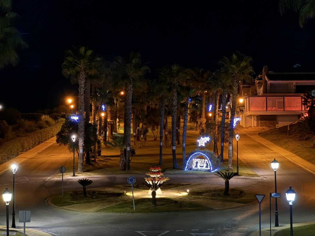 Avenida del complejo iluminada al anochecer.